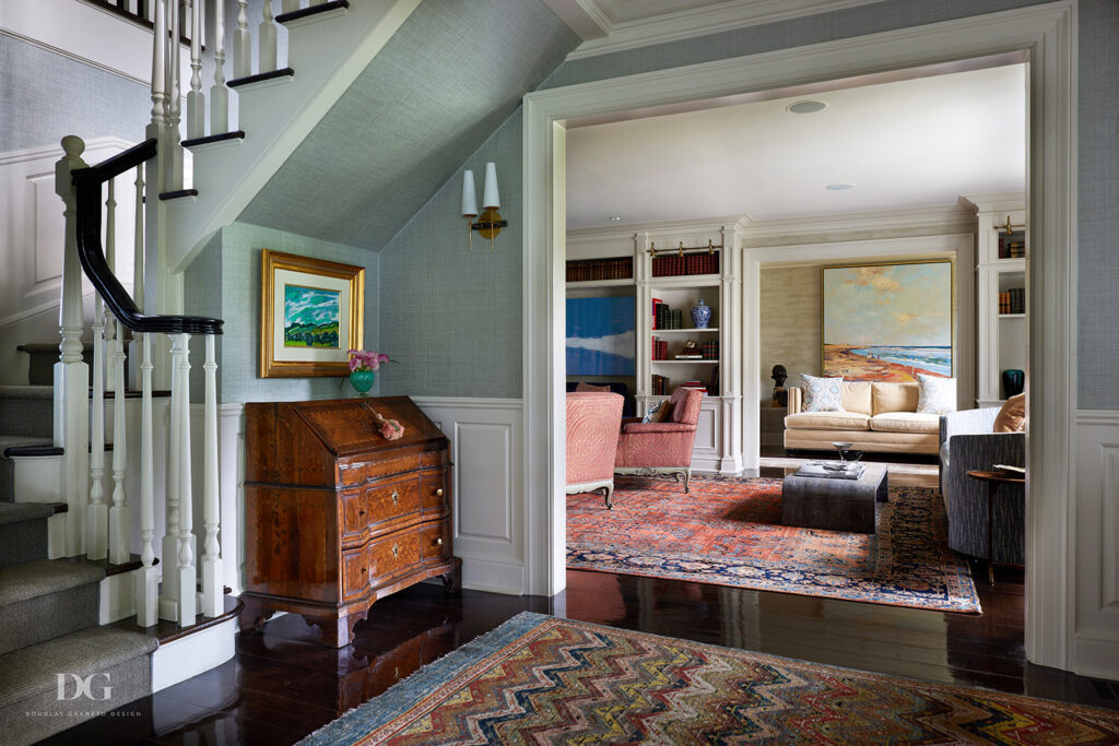 Entryway of a classic home, looking into and through a living room, with antique rugs
