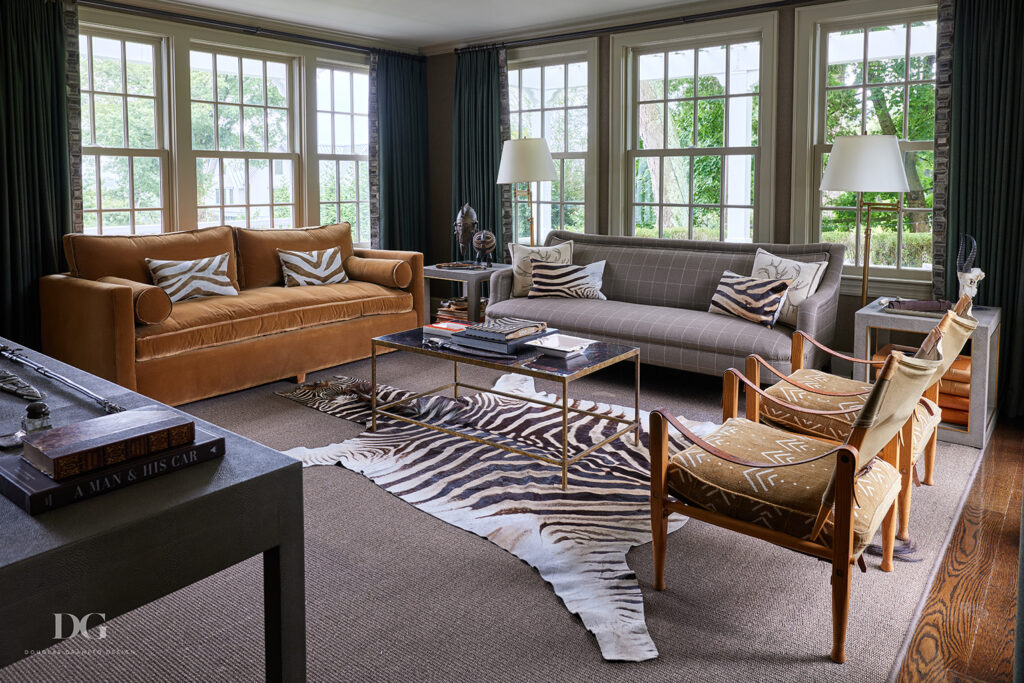 The seating area of a home office with windows on three sides. A George Smith sofa and a pair of vintage Kaare Klint chairs