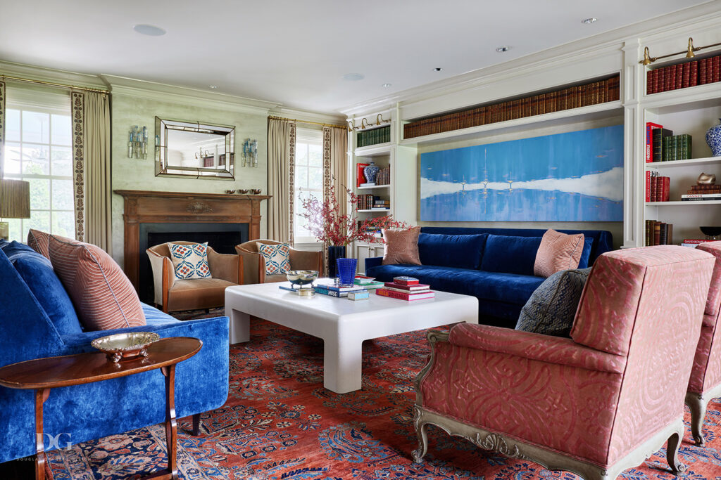 A living room with a pair of Dimitriy & co blue sofas, vintage art deco chairs and an antique rug