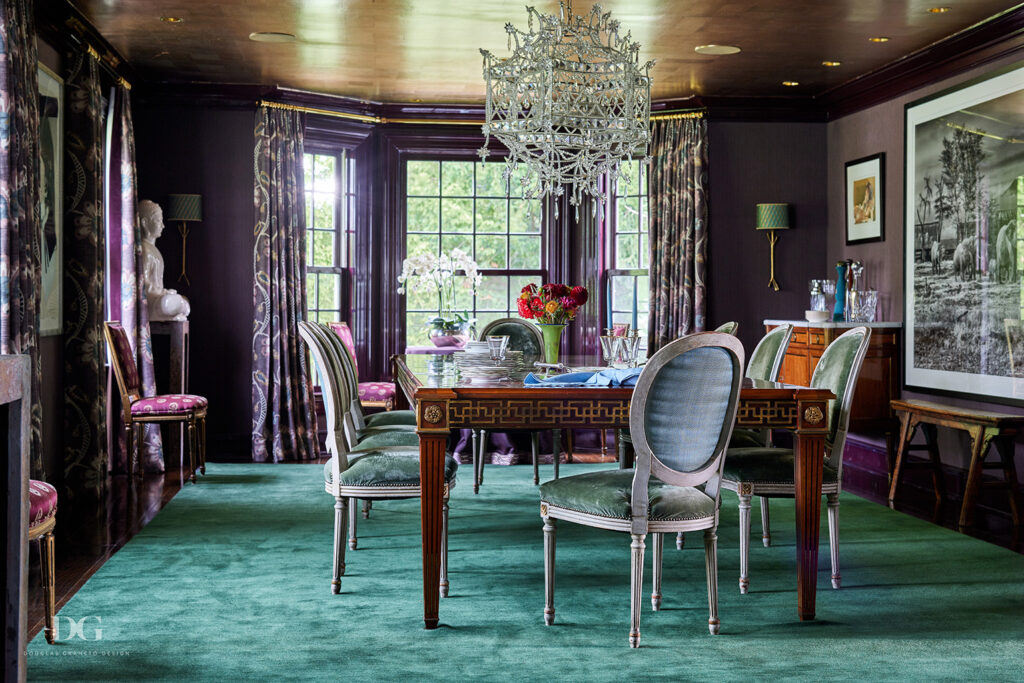 A dining room with purple walls painted using Fine Paints of Europe, Holly Hunt gold ceiling, and Zimmer & Rohde curtains. The carpet is green and the dining table is vintage.