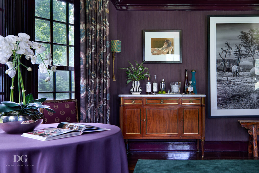 View of a wood sideboard with white marble top, in a purple dining room