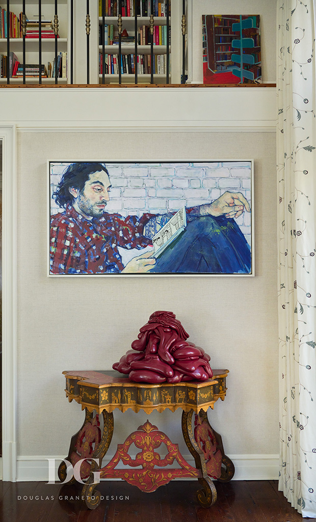 Detail of a corner of a living room with a vintage decorative console table and art hanging above